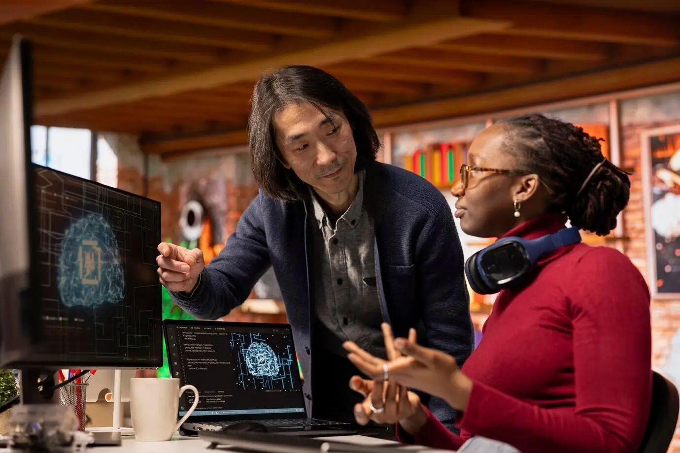 Dirigente senior che assiste un dipendente in un’agenzia di sviluppo di software di intelligenza artificiale.